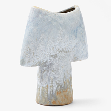 Back view product photography of an asymmetrical glazed ceramic vase showing the alternative angle of the textured light blue and tan glaze.
