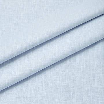 Close-up detail photography of light blue linen fabric neatly folded to display the thickness, drape, and material quality.