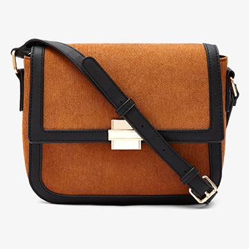 Front view e-commerce product shot of a tan suede crossbody handbag with black leather trim and a gold front clasp.